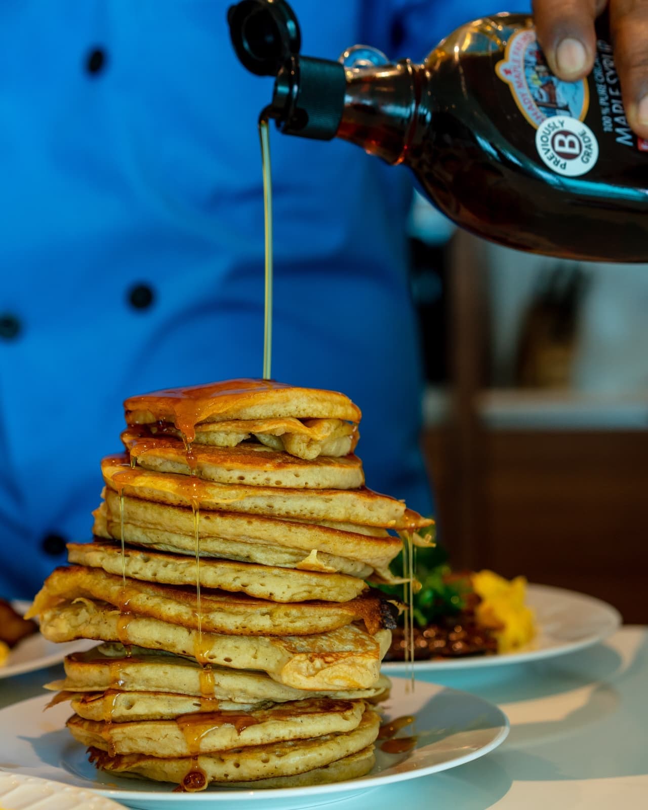 Stacked pancakes finished tableside with maple syrup